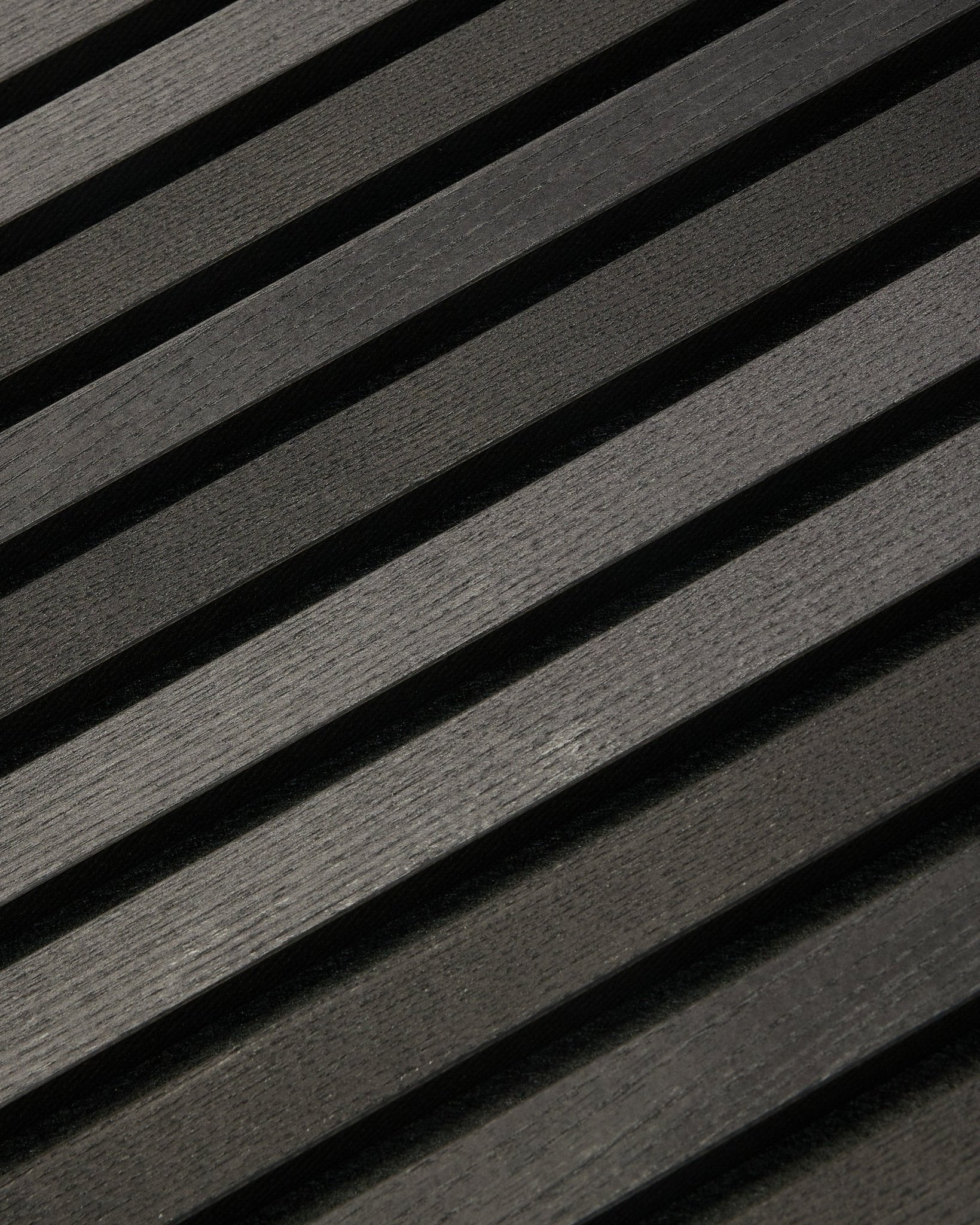 Tonal Akupanel i Black Ash (300 x 60 cm) fra WoodUpp, et mørkt diagonalt Akustikpanel med teksturerede, skandinavisk inspirerede lameller til indendørs vægge.